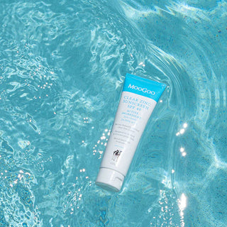 MooGoo sunscreen bottle on a blue water background